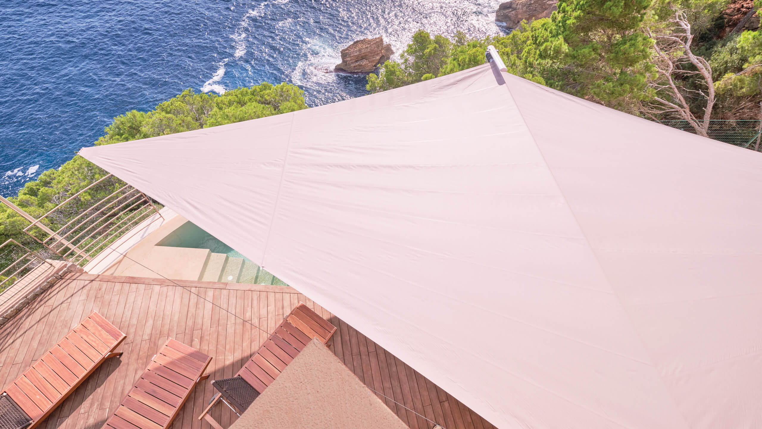 Best automatic Sun Sail on Mallorca luxury villa terrace — sail deployed over pool with Tramuntana backdrop, 2000+ Balearic installations, patented wind sensor since 1993