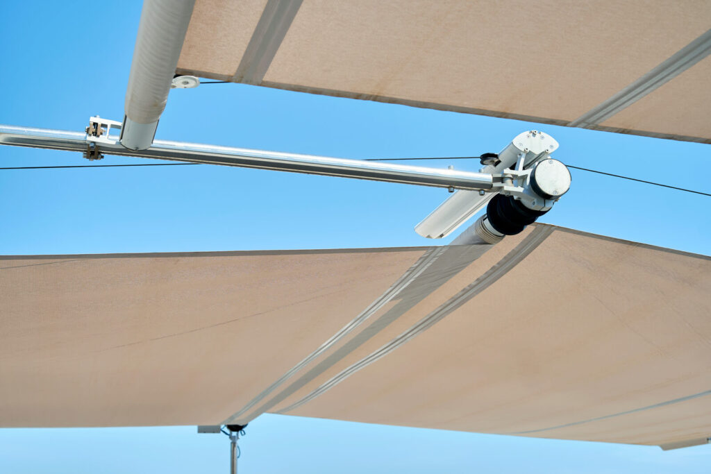 Complete Sun Sail patented system installed on Mallorca luxury villa terrace — anemometer at mast apex, soft-tension cassette, sail fully deployed
