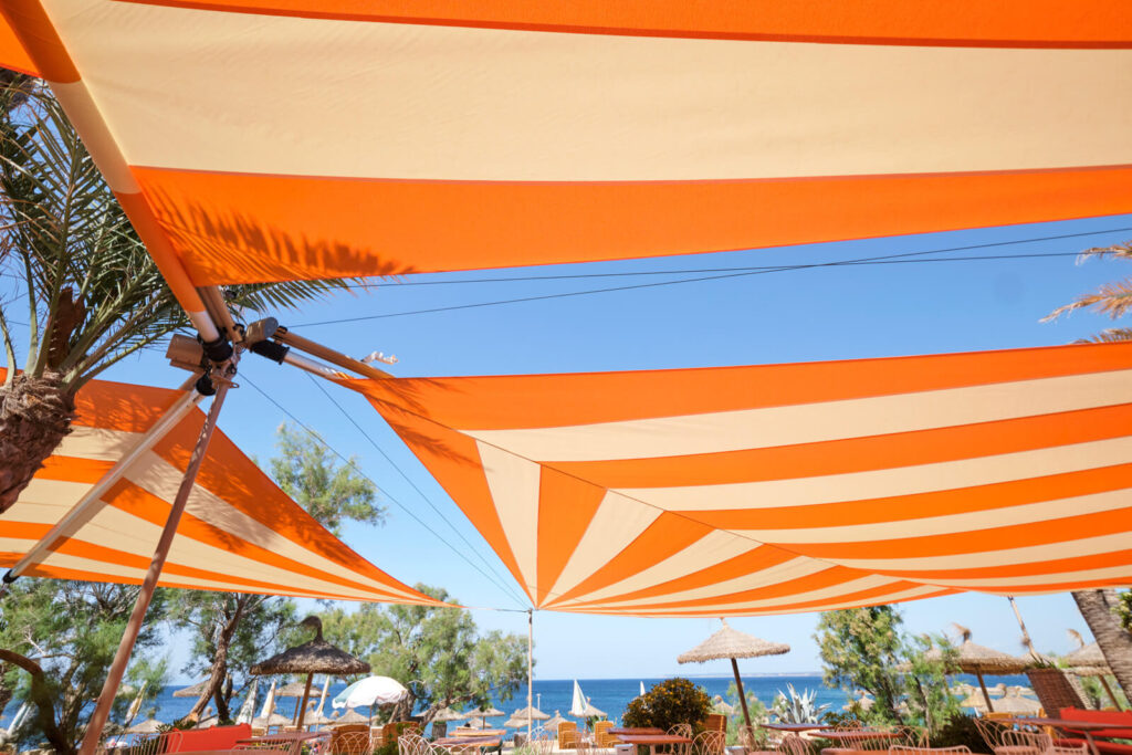 SunSquare installation at boutique hotel pool terrace in Sóller Valley Mallorca, 120 m² two-sail configuration exposed to Tramuntana conditions