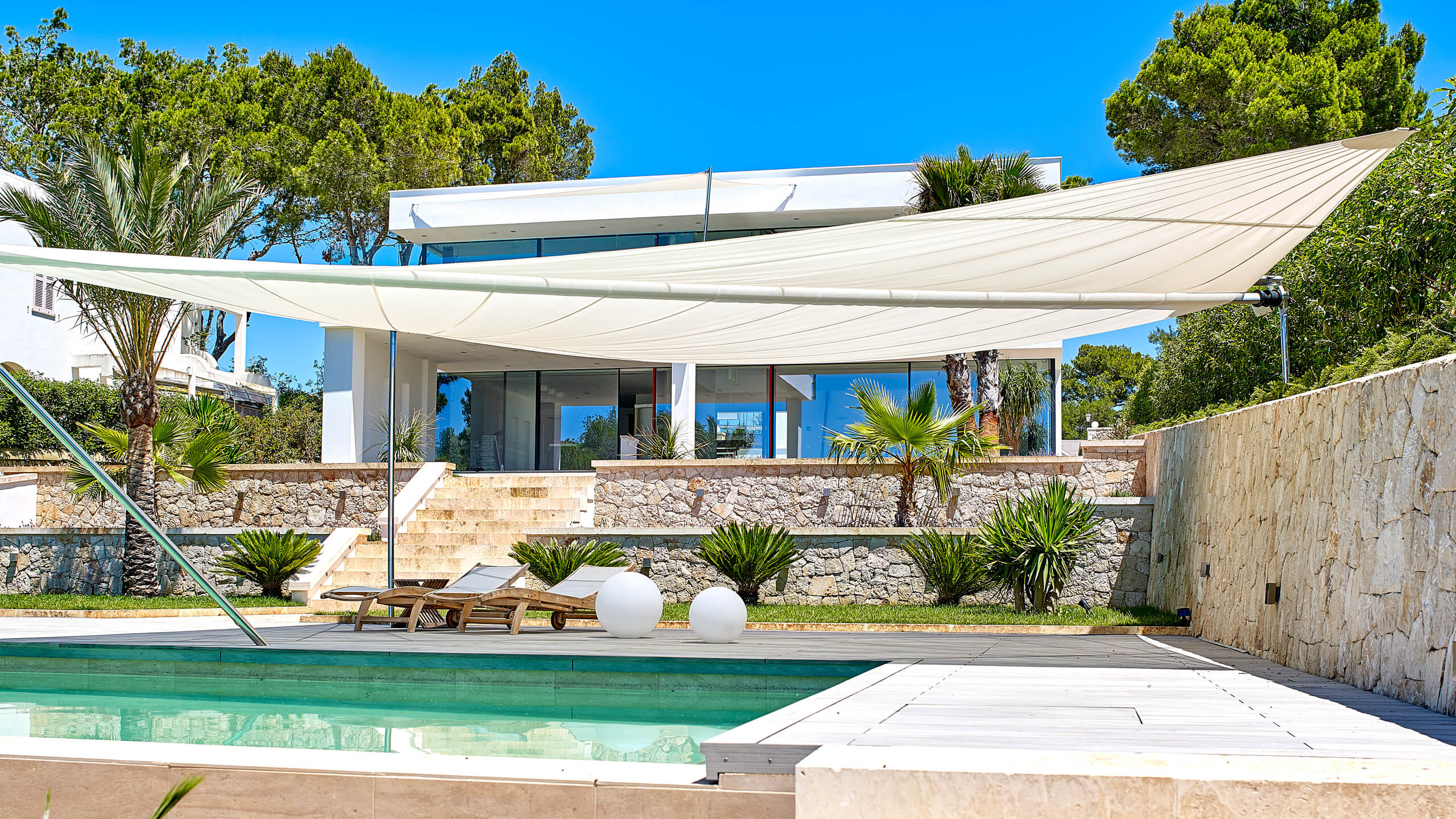 Side-by-side comparison of SunSquare automatic sun sail and bioclimatic pergola on Ibiza villa terrace, same lighting conditions