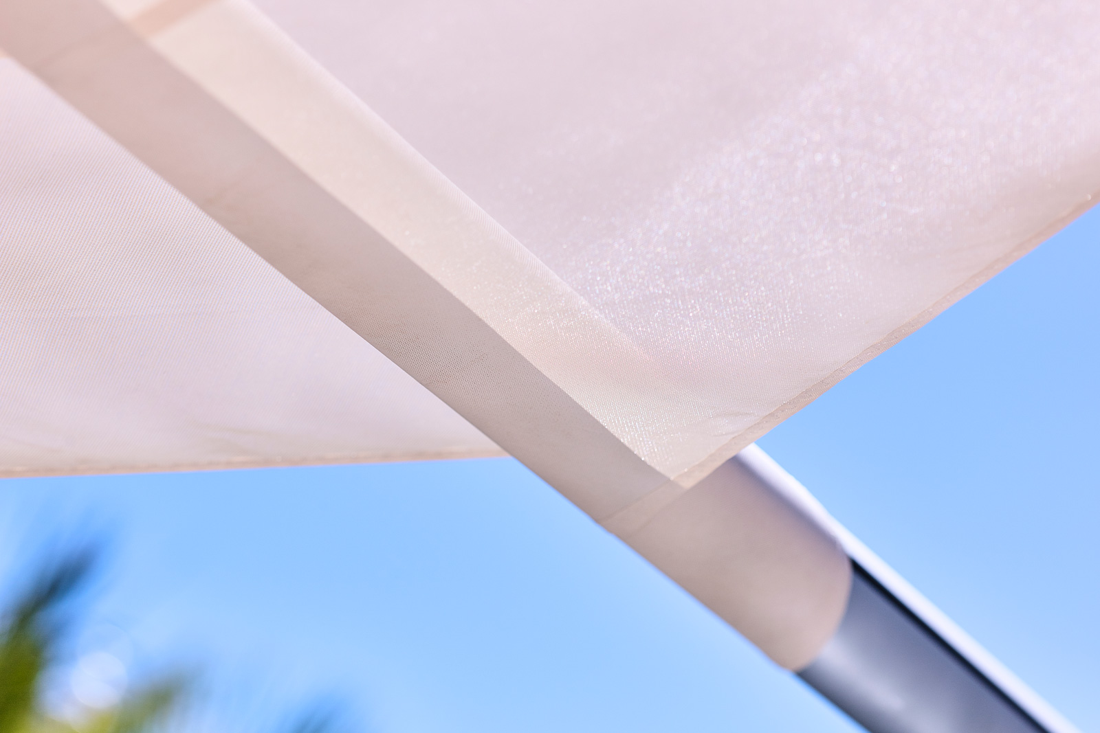 SunSquare waterproof sail deployed during rain on Ibiza villa terrace, occupants dry underneath