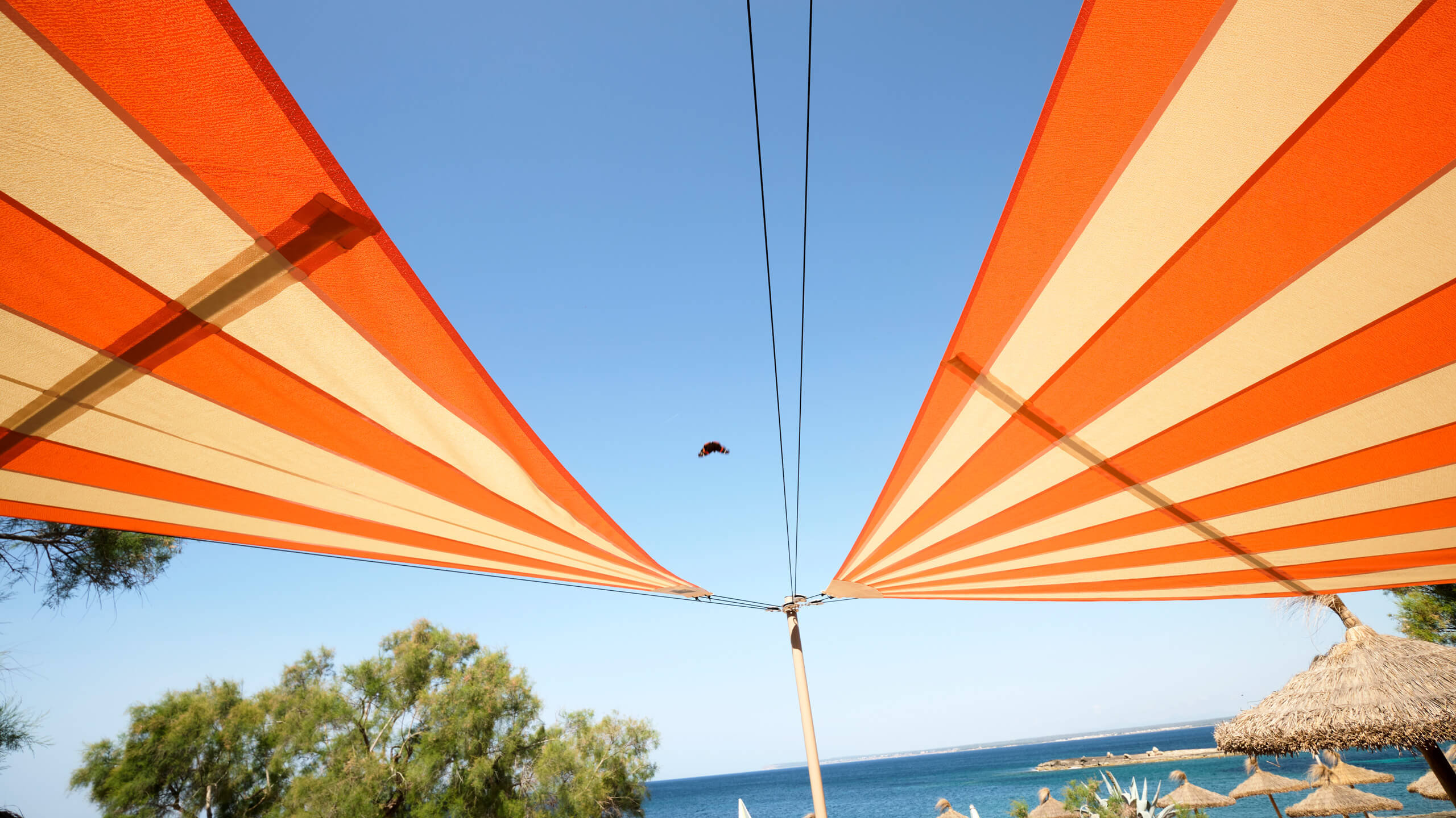 SunSquare automatic wind-resistant shade sail deployed over exposed commercial restaurant terrace in Mallorca